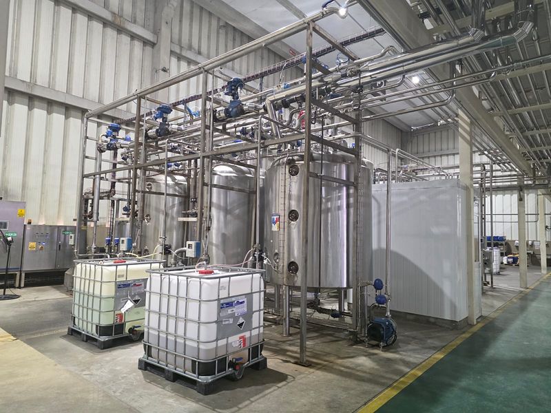 Central CIP de 2 linhas com tanques de aço inox, válvulas de controle e contêineres de produtos de limpeza