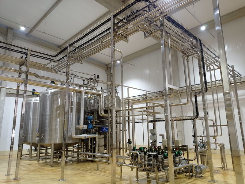 Tanques de armazenagem em aço inox ligados à tubulação e ao manifold de válvulas